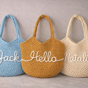 May include: A white ceramic mug with a black handle and the text "But First, Coffee" in a bold, black font. The mug is set against a blurred background, highlighting its clean design.