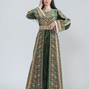 May include: A long, dark green dress with intricate embroidery in shades of orange, yellow, and green. The dress features long sleeves, a fitted waist, and a flowing skirt. The neckline and cuffs are trimmed with a cream-colored fabric.