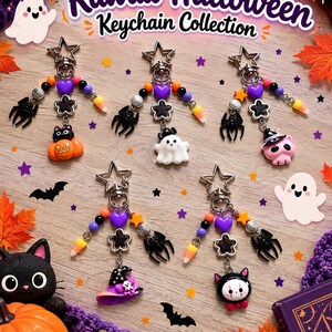 May include: Five Halloween-themed keychains featuring star-shaped clasps, colorful beads, black spider charms, and various pendants including a pumpkin, ghost, skull, witch hat, and cat. The text reads Kawaii Halloween Keychain Collection.