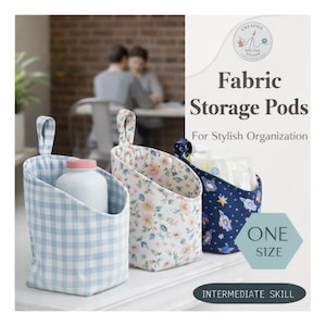 May include: Three fabric storage pods in different patterns: light blue gingham, floral, and navy with rockets. Each pod has a loop handle. The text reads "Fabric Storage Pods For Stylish Organization" and "ONE SIZE".