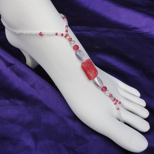 May include: A red and clear beaded foot jewelry with a large red stone charm.