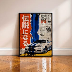 Peut inclure: Une affiche encadrée représentant une Nissan Skyline GT-R blanche avec des bandes de course bleues. Le fond présente un panneau rouge avec du texte japonais, des coulures de peinture bleue et une mise en page style journal avec le texte Nissan GT-R.