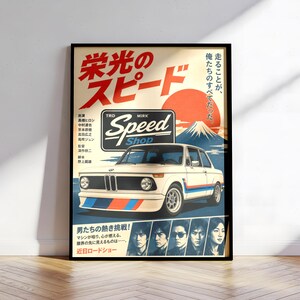 Peut inclure: Une affiche encadrée représentant une voiture BMW vintage blanche avec des bandes de course bleues et rouges. Le design inclut un grand soleil rouge, le mont Fuji, le texte "TRD MIRK Speed Shop", des caractères japonais et cinq portraits.