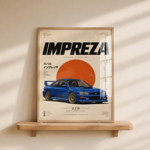 Könnte beinhalten: Ein gerahmtes Poster mit einem blauen Subaru Impreza 22B Auto, zentriert unter einem großen orangefarbenen Kreis. Der Text lautet IMPREZA, LEGEND LIVES ON, 22B, 1998-2000 sowie japanische Schriftzeichen. Der Hintergrund ist cremefarben und gealtert.