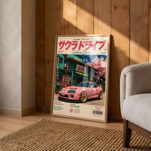 Könnte beinhalten: Ein vertikales Poster mit einem rosa Toyota Supra MK4, der vor einem Gebäude mit japanischem Text geparkt ist. Das Poster enthält den Titel Sakura Drive, einen Strichcode und technische Daten des Fahrzeugs auf hellem Hintergrund.