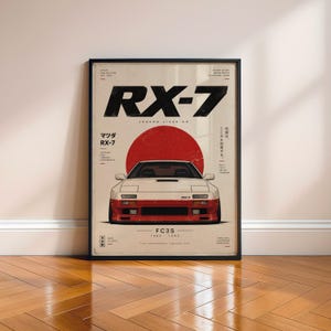 Puede incluir: Un póster vertical enmarcado que muestra un coche deportivo Mazda RX-7 FC3S blanco y rojo centrado bajo un gran círculo rojo. El texto RX-7 está impreso en letras negras grandes en la parte superior, con texto en japonés e inglés alrededor.