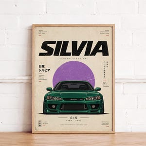 Puede incluir: Un póster enmarcado que muestra un coche deportivo Nissan Silvia S15 de color verde oscuro centrado bajo un gran círculo morado. El texto dice SILVIA, LEGEND LIVES ON, S15, 1999-2002, e incluye caracteres japoneses y especificaciones técnicas en negro.