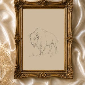 May include: A rectangular wall art piece featuring a black ink sketch of a bison on a beige background, encased in an ornate, antique-style gold frame with intricate floral and scrollwork detailing along the edges.
