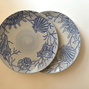 Set of two stoneware, vintage blue shell-motif plates from discontinued Pottery Barn "Blue-Shell" line, for coastal or beach style decor.