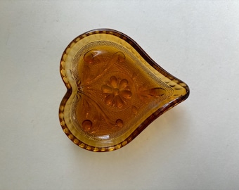 An “Indiana Glass” amber/gold small heart-shaped Tiara line sandwich pattern dish, for small trinkets/ vide poche