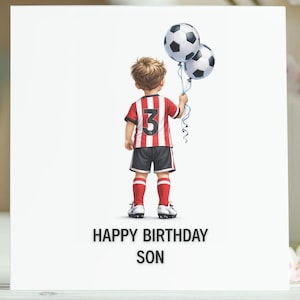 May include: A white birthday card with the text "HAPPY BIRTHDAY SON" shows a boy in a red and white football kit holding two football-shaped balloons. The card is set against a backdrop of flowers and pastel-coloured eggs.