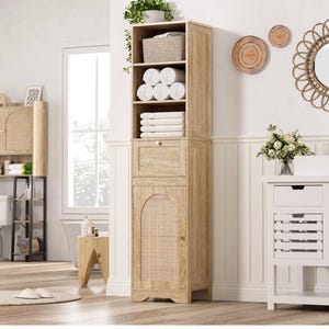 May include: A tall, light-colored wooden storage cabinet with multiple shelves and a lower cabinet with a woven cane door. The shelves hold rolled and folded white towels, and a woven basket. A small drawer is visible.