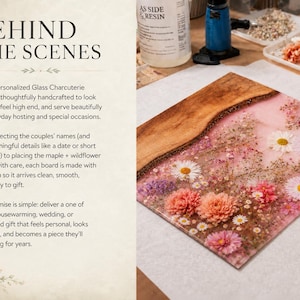 May include: A personalized glass charcuterie board with a wooden edge and a floral design. The board features a pink background with embedded flowers in shades of white, pink, and purple. The text "BEHIND THE SCENES" is visible.
