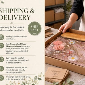 May include: A personalized glass charcuterie board with a floral design, featuring pink and white flowers encased in clear resin. The board is presented in a cardboard box with a wooden spatula. The text "Thank You" is on a small card.