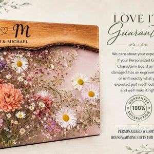 May include: A personalized charcuterie board with a wooden edge and a floral design. The board features the initials "S & M" with "Sarah & Michael" below. The board is decorated with pink, white, and purple flowers.