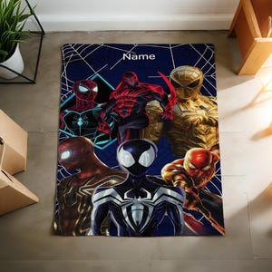 May include: A rectangular blanket featuring a dark blue background with a white spiderweb pattern and the word Name printed at the top. The design displays six different Spider-Man characters in various red, black, gold, and blue suits.