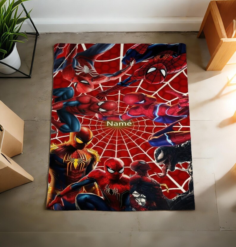 May include: A rectangular blanket featuring a vibrant red spiderweb pattern background with multiple illustrations of Spider-Man in various action poses and a black Venom character. The word Name is printed in the center of the design.