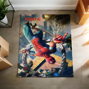 May include: A rectangular blanket featuring a vibrant graphic print of Spider-Man in a red and blue suit battling Doctor Octopus with his mechanical tentacles. The word Name is printed in red at the top center of the design against a city background.
