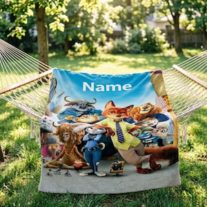 May include: A blue blanket featuring characters from the animated movie Zootopia, with the word "Name" in white. The blanket is draped over a hammock in a grassy outdoor setting, with trees in the background.