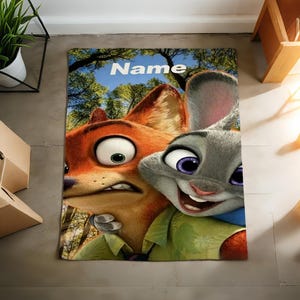 May include: A rectangular rug featuring the animated characters Nick Wilde and Judy Hopps from Zootopia. The rug has a blue sky and tree background, with the word "Name" in white letters at the top.