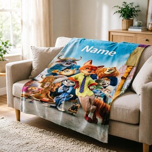 May include: A plush blanket featuring characters from the animated movie Zootopia. The blanket has a blue sky background with the word "Name" printed on it. The blanket is draped over a beige sofa.