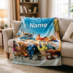May include: A plush, blue blanket featuring characters from a popular animated movie. The blanket has a light blue background with the word "Name" in white. The blanket is draped over a beige sofa in a living room setting.