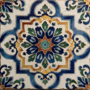 May include: A square ceramic tile featuring a symmetrical, intricate floral pattern in shades of deep blue, forest green, and golden yellow against a textured off-white background. The design centers on a star-shaped motif with curved edges.