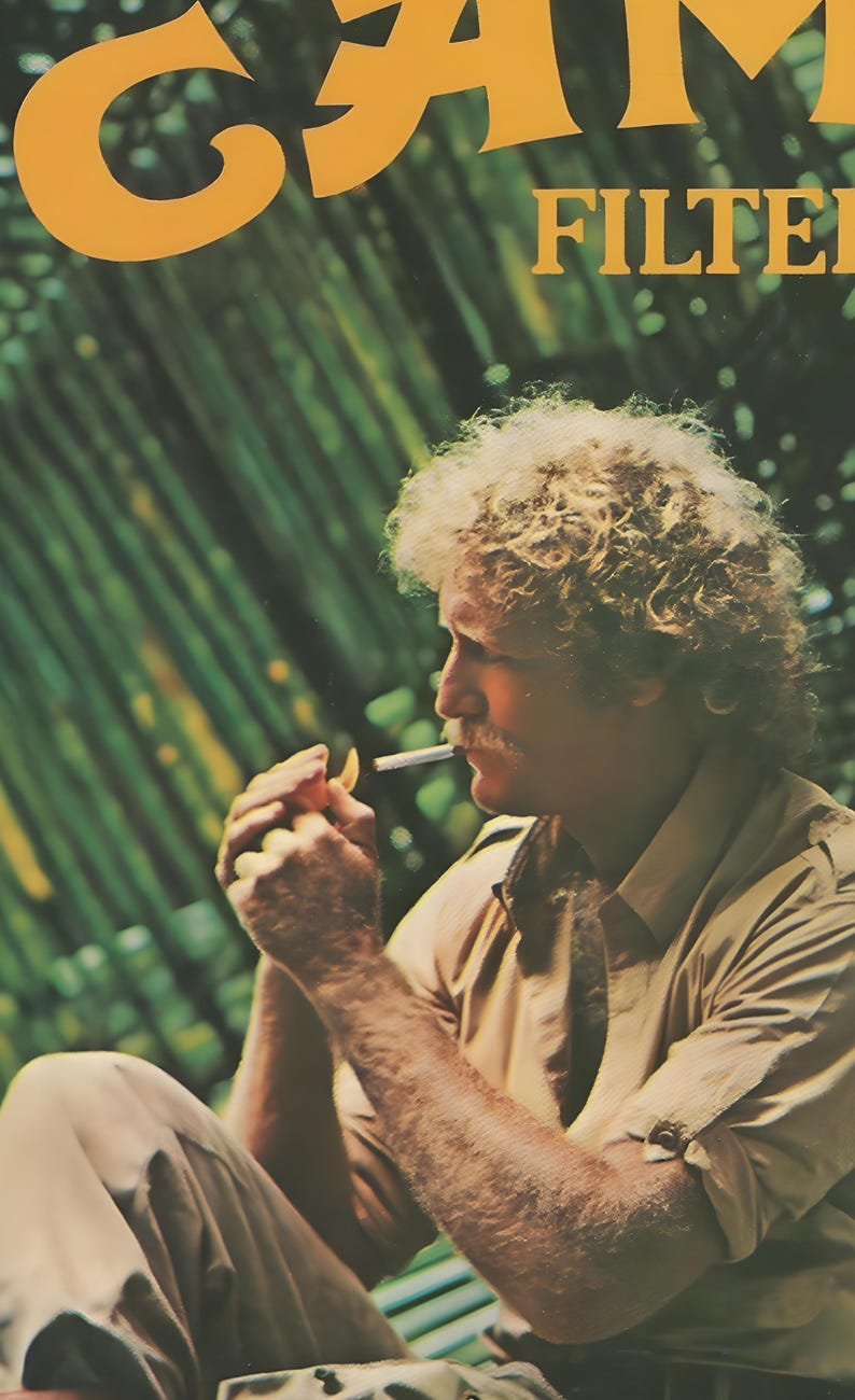 May include: A vintage advertisement poster featuring a person with curly blonde hair and a mustache, wearing a tan button-down shirt. The person is holding a lit cigarette to their lips. The text CAMEL FILTER is visible in yellow.