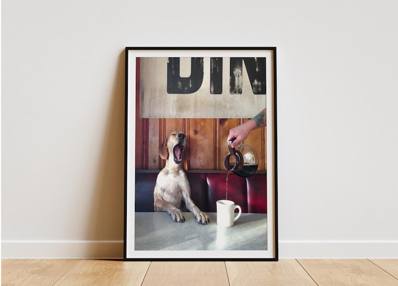 May include: Framed print featuring a dog yawning in a diner booth as coffee is poured into a mug. The word "DIN" is visible above the dog. The scene is set in a diner with red booth seating and wooden paneling.