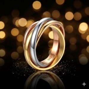 Könnte beinhalten: Ein Ring mit drei ineinandergreifenden Bändern in Gold, Silber und Roségold. Der Ring besteht aus S925 Sterlingsilber und hat eine polierte Oberfläche. Der Hintergrund ist mit Bokeh-Lichtern verschwommen.