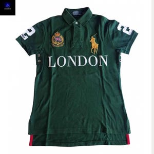 Puede incluir: Una taza de cerámica blanca con asa negra y el texto "But First, Coffee" en negrita negra. La taza se encuentra sobre un fondo borroso, sugiriendo un ambiente acogedor.