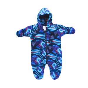 May include: A blue fleece baby onesie with a hood. The onesie has a colorful fish pattern.