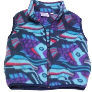 May include: A blue, purple, and teal fleece vest with a geometric pattern. The vest has a zipper closure and a navy blue trim.