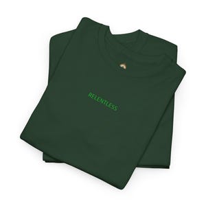 Puede incluir: Dos camisetas verde oscuro apiladas sobre un fondo blanco. La palabra "RELENTLESS" está bordada en verde en la parte delantera de la camiseta superior. Las camisetas están cuidadosamente dobladas, mostrando el diseño de cuello redondo.
