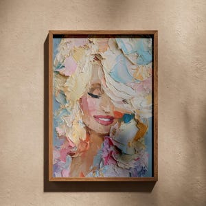 Op de afbeelding: Een ingelijste kunstdruk met een dik impasto olieverfschilderij van een persoon met volumineus blond haar. Het portret gebruikt een palet van pastelroze, blauwe en gele tinten met een zware textuur, gevat in een eenvoudige houten lijst.