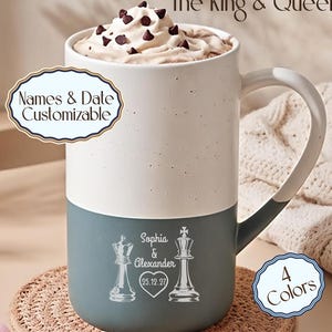 May include: A two-toned ceramic mug with a speckled cream top and a solid dark gray bottom. The mug features a white graphic of a queen and king chess piece, the names Sophia & Alexander, and the date 25.12.27 inside a heart. Text reads The King & Queen.