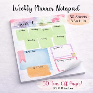 May include: Weekly planner notepad with a watercolor design. The notepad has sections for each day of the week, a to-do list, and space for top tasks. It measures 8.5 x 11 inches and has 50 tear-off pages.