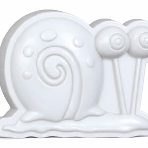 May include: A white, three-dimensional snail figurine. The snail has a rounded shell with a spiral design and several small, raised circles. It features large, protruding eyes on stalks and sits on a wavy base. The figurine is made of a smooth, glossy material.