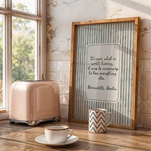 Op de afbeelding: Een witte keramische mok met een zwart handvat en de tekst "But First, Coffee" in een zwarte, handgeschreven lettertype. De mok staat op een wit oppervlak.