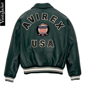 May include: Dark green leather jacket with the word "AVIREX" across the back, above a patch with the American flag and the words "ALL AMERICANS ESTABLISHED 1975". The word "USA" is below the patch. The jacket has white and black striped cuffs and hem.