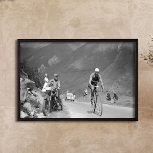 May include: Black and white framed print of a vintage bicycle race on a mountain road. The image shows cyclists, motorcycles, and a car on a winding road. The words "Black Frame" are printed at the top left of the image.