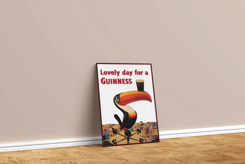 May include: Framed poster with a vintage Guinness advertisement. The artwork features a toucan with a large orange beak holding a pint of Guinness. Text reads "Lovely day for a Guinness."