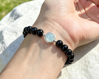 Pulsera de cuentas de aguamarina y obsidiana natural con detalles de cristal azul.