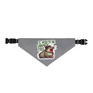 Puede incluir: Bandana triangular gris para mascotas con hebillas ajustables negras. La bandana presenta un gráfico de una zarigüeya con la boca abierta y el texto "I NEED TO BE DRAMATIC FIRST".