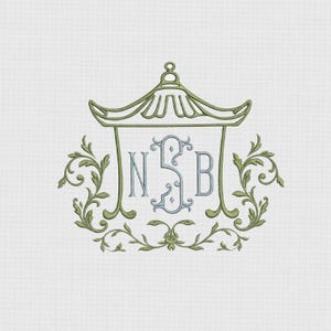 May include: An embroidery design featuring a light green pagoda-style roof outline framing a central light blue monogram with the letters N, S, and B. The design is accented by symmetrical light green scrolling leaf and vine motifs on both sides.