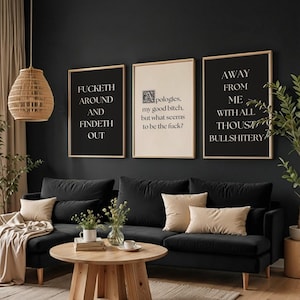 Può includere: Un set di tre stampe da parete incorniciate con cornici in legno chiaro. Le stampe a sinistra e a destra sono nere con testo bianco: FUCKETH AROUND AND FINDETH OUT e AWAY FROM ME WITH ALL THOUST BULLSHITERY. La stampa centrale è color crema.