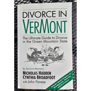 May include: A white paperback book titled Divorce in Vermont: The Ultimate Guide to Divorce in the Green Mountain State. The cover features a black and white cartoon of two people in separate canoes, authored by Nicholas Hadden, Cynthia Broadfoot, and John Pavese.