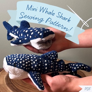 May include: Two plush whale shark toys made of dark blue fabric with white polka dots and white underbellies. A light blue banner at the top displays the text Mini Whale Shark Sewing Pattern! and a white needle icon. A PDF Download label is at the bottom.
