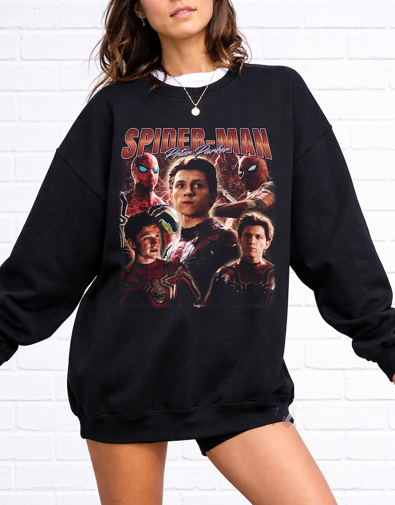 May include: Black sweatshirt featuring a graphic of Spider-Man with the text "Spider-Man Peter Parker" in red and orange. The design includes multiple images of the character in his suit. The sweatshirt has a crew neck and long sleeves.