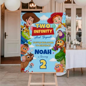 May include: A rectangular birthday sign on a wooden easel featuring a light blue background with white clouds and colorful cartoon characters. The text reads: TWO INFINITY And Beyond! YOU'RE WELCOME TO BIRTHDAY NOAH is turning 2 in yellow and blue.